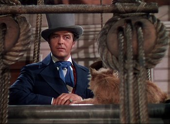 Movie still from “Reap the Wild Wind” (1942), directed by Cecil B. DeMille – A man wearing a top hat and a suit and tie; Medium shot, Low angle