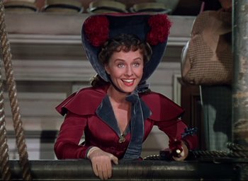 Movie still from “Reap the Wild Wind” (1942), directed by Cecil B. DeMille – A woman wearing a red dress and a blue hat; Medium shot, Low angle