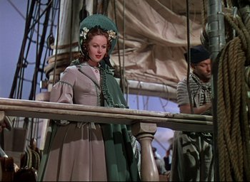 Movie still from “Reap the Wild Wind” (1942), directed by Cecil B. DeMille – A woman dressed in period clothing standing next to a man; Medium shot, Low angle