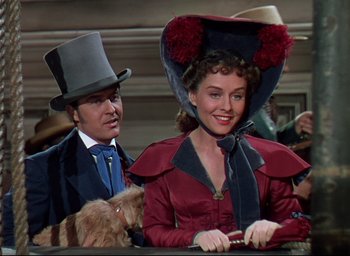 Movie still from “Reap the Wild Wind” (1942), directed by Cecil B. DeMille – A man and a woman wearing hats with a dog; Medium shot, Low angle