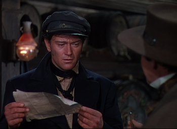 Movie still from “Reap the Wild Wind” (1942), directed by Cecil B. DeMille – A man wearing a hat looking down at a piece of paper; Close Up shot, Over the shoulder angle