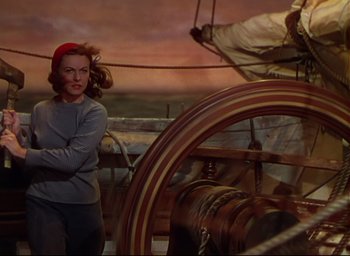 Movie still from “Reap the Wild Wind” (1942), directed by Cecil B. DeMille – A woman standing in front of a steering wheel on a boat; Medium shot, High angle