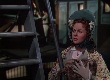 Movie still from “Reap the Wild Wind” (1942), directed by Cecil B. DeMille – A woman wearing a hat standing in front of a ladder; Medium shot, Over the shoulder angle