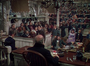 Movie still from “Reap the Wild Wind” (1942), directed by Cecil B. DeMille – A group of people sitting at a table in a room; Wide shot, High angle