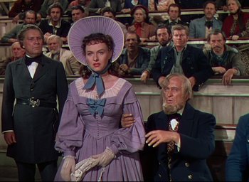Movie still from “Reap the Wild Wind” (1942), directed by Cecil B. DeMille – An old man and a woman standing in front of an audience; Medium shot, Over the shoulder angle