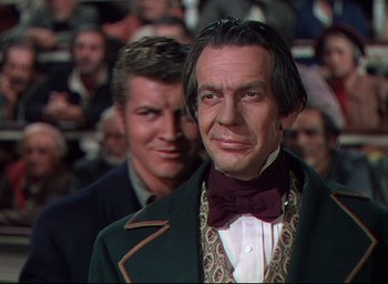 Movie still from “Reap the Wild Wind” (1942), directed by Cecil B. DeMille – A man in a suit and tie standing next to another man in a suit and tie; Medium shot, Over the shoulder angle