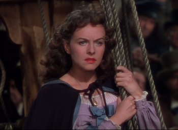 Movie still from “Reap the Wild Wind” (1942), directed by Cecil B. DeMille – A beautiful woman with long curly brown hair holding onto a rope; Close Up shot, Over the shoulder angle