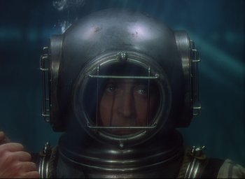 Movie still from “Reap the Wild Wind” (1942), directed by Cecil B. DeMille – A person wearing a diving suit in the water; Close Up shot, Overhead angle