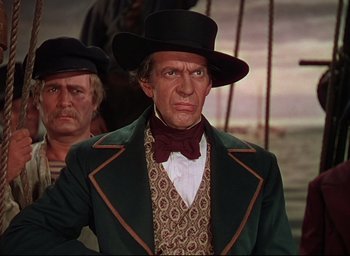 Movie still from “Reap the Wild Wind” (1942), directed by Cecil B. DeMille – A man wearing a green jacket and a black hat; Medium shot, Low angle