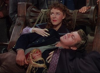 Movie still from “Reap the Wild Wind” (1942), directed by Cecil B. DeMille – A man and a woman laying on the ground; Medium shot, High angle