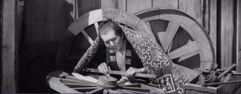 Movie still from “Red Beard” (1965), directed by Akira Kurosawa – An old photo of a man working on a wooden wheel; Medium shot, High angle