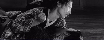 Movie still from “Red Beard” (1965), directed by Akira Kurosawa – A woman in a kimono is holding a man in his arms; Close Up shot, Low angle