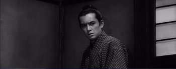 Movie still from “Red Beard” (1965), directed by Akira Kurosawa – A black and white photo of a man in a polka dot shirt; Close Up shot, Low angle