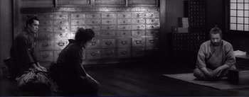 Movie still from “Red Beard” (1965), directed by Akira Kurosawa – A woman kneeling on the floor in front of a wall of drawers; Wide shot, High angle