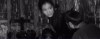 Movie still from “Red Beard” (1965), directed by Akira Kurosawa – A young girl is looking at the camera while standing in the rain; Medium shot, High angle
