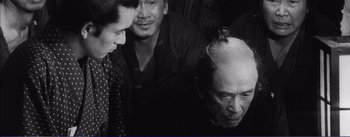 Movie still from “Red Beard” (1965), directed by Akira Kurosawa – A group of men standing next to each other in a room; Medium shot, Over the shoulder angle