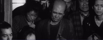 Movie still from “Red Beard” (1965), directed by Akira Kurosawa – An older man crying in a crowd of people; Medium shot, High angle