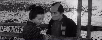 Movie still from “Red Beard” (1965), directed by Akira Kurosawa – An old photo of a man and a young woman; Medium shot, Low angle
