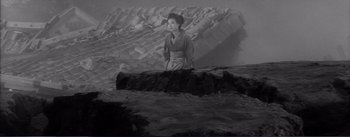 Movie still from “Red Beard” (1965), directed by Akira Kurosawa – A woman standing on top of a pile of rocks; Extreme Wide shot, High angle