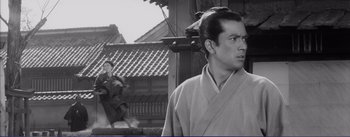 Movie still from “Red Beard” (1965), directed by Akira Kurosawa – A man wearing a robe standing in front of a building; Medium shot, Low angle