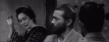 Movie still from “Red Beard” (1965), directed by Akira Kurosawa – Black and white photograph of a man with long hair; Close Up shot, Over the shoulder angle