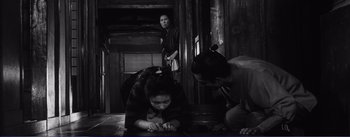 Movie still from “Red Beard” (1965), directed by Akira Kurosawa – A group of people standing around in a room; Wide shot, High angle