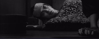 Movie still from “Red Beard” (1965), directed by Akira Kurosawa – A man laying on the ground with his head on a pillow; Close Up shot, High angle