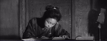 Movie still from “Red Beard” (1965), directed by Akira Kurosawa – A woman in a kimono is looking down at a piece of paper; Medium shot, Low angle