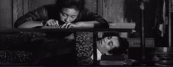 Movie still from “Red Beard” (1965), directed by Akira Kurosawa – A woman leaning over a man laying on the ground; Medium shot, High angle