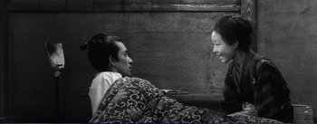 Movie still from “Red Beard” (1965), directed by Akira Kurosawa – Two people are sitting in a bed and talking to each other; Medium shot, High angle