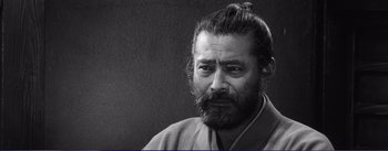 Movie still from “Red Beard” (1965), directed by Akira Kurosawa – Black and white photograph of a man with a beard; Close Up shot, Low angle