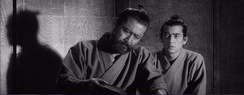 Movie still from “Red Beard” (1965), directed by Akira Kurosawa – A man with a long beard and a man with long hair; Close Up shot, Low angle
