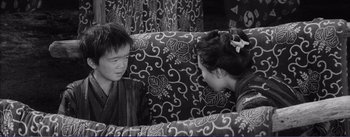 Movie still from “Red Beard” (1965), directed by Akira Kurosawa – A man and a woman sitting on top of a couch; Medium shot, High angle