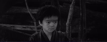 Movie still from “Red Beard” (1965), directed by Akira Kurosawa – A young asian boy in front of a forest; Close Up shot, High angle