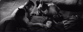 Movie still from “Red Beard” (1965), directed by Akira Kurosawa – A group of people are gathered around a young child; Medium shot, High angle