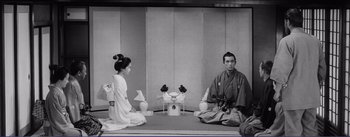 Movie still from “Red Beard” (1965), directed by Akira Kurosawa – A man and a woman sitting in front of each other; Wide shot, High angle