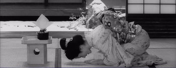 Movie still from “Red Beard” (1965), directed by Akira Kurosawa – A woman in a geisha outfit doing a yoga pose; Medium shot, High angle