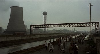 Movie still from “Red Desert” (1964), directed by Michelangelo Antonioni – A group of people walking across a bridge; Extreme Wide shot, High angle