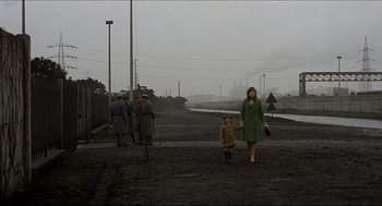 Movie still from “Red Desert” (1964), directed by Michelangelo Antonioni – A woman and a little girl are walking in the dirt; Wide shot, High angle