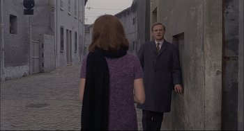 Movie still from “Red Desert” (1964), directed by Michelangelo Antonioni – A man and a woman are walking down the street; Medium shot, Over the shoulder angle