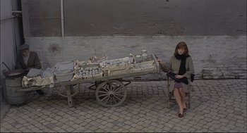 Movie still from “Red Desert” (1964), directed by Michelangelo Antonioni – A woman sitting in front of an antique cart; Wide shot, High angle