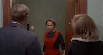 Movie still from “Red Desert” (1964), directed by Michelangelo Antonioni – A woman standing in front of two men in front of a mirror; Medium shot, Over the shoulder angle