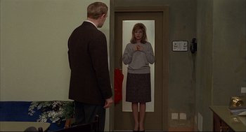 Movie still from “Red Desert” (1964), directed by Michelangelo Antonioni – A man and a woman standing in front of a door; Medium shot, Over the shoulder angle