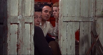 Movie still from “Red Desert” (1964), directed by Michelangelo Antonioni – A group of men and women sitting next to each other; Medium shot, Low angle