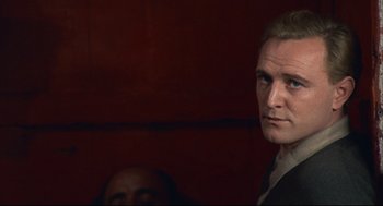 Movie still from “Red Desert” (1964), directed by Michelangelo Antonioni – A person in a dark room; Close Up shot, Over the shoulder angle