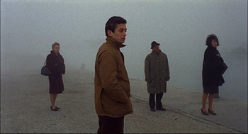 Movie still from “Red Desert” (1964), directed by Michelangelo Antonioni – A group of people standing on top of a hill; Medium shot, High angle