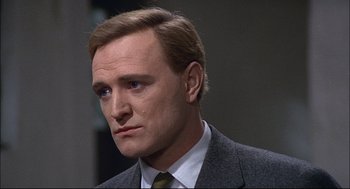 Movie still from “Red Desert” (1964), directed by Michelangelo Antonioni – A person wearing a suit and tie; Close Up shot, Over the shoulder angle