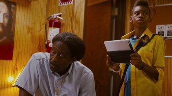 Movie still from “Red Hook Summer” (2012), directed by Spike Lee – A man in a white shirt and a man in a yellow and blue jacket; Medium shot, Over the shoulder angle
