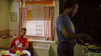 Movie still from “Red Hook Summer” (2012), directed by Spike Lee – A man and a woman in a room with a window in the background; Medium shot, Over the shoulder angle