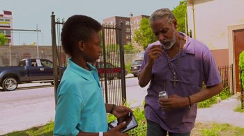 Movie still from “Red Hook Summer” (2012), directed by Spike Lee – Two men standing next to each other on a sidewalk; Medium shot, Over the shoulder angle